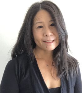 This is a headshot of Susan S. Wong, the owner of this business. She is an Asian woman with long black hair parted in the middle. She is wearing a black sweater over a black scoop neck top.